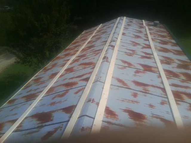 Rusted metal roof panels with new wood purlins before replacement — Storm Damage Roof Repair in Stanfield by Roofing Brothers