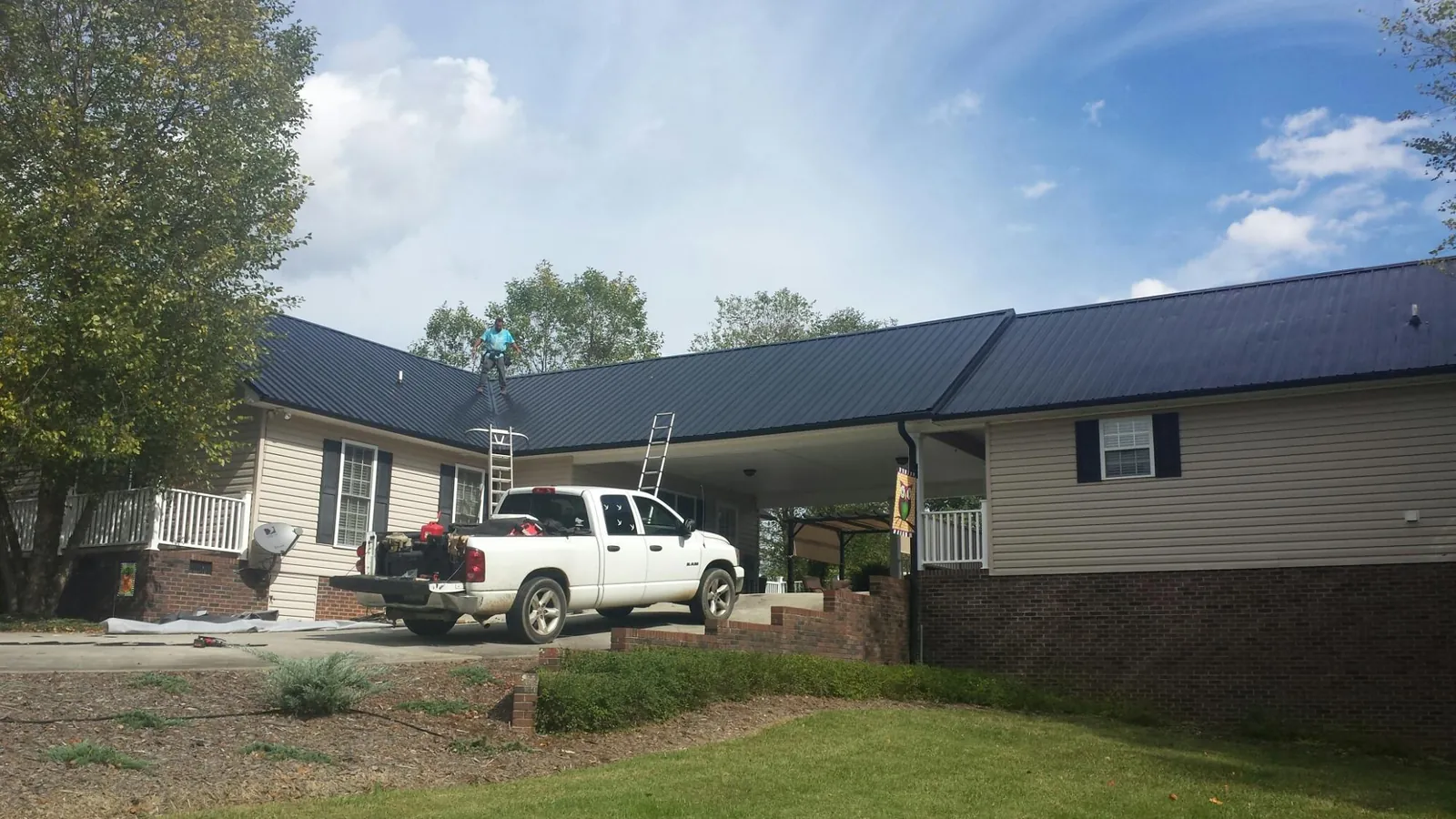 Black metal roof over a home and attached breezeway with ladders set in Stanfield